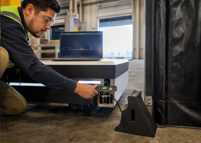 Technician adjusting 2D LiDAR height near a dark wheel chock