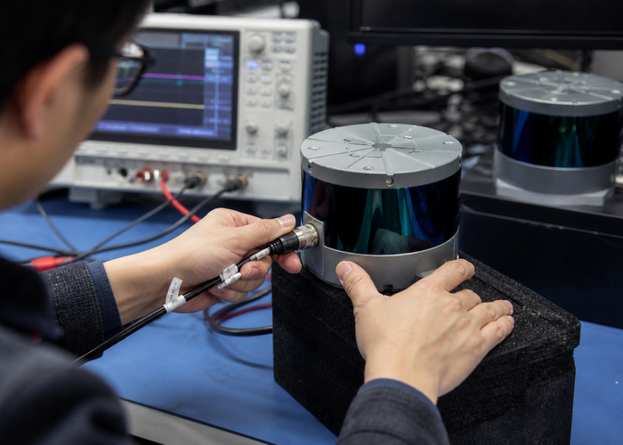 LiDAR engineering team diagnosing a returned sensor in a professional electronics laboratory validation scene 2