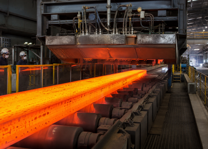 industrial LiDAR profiler measuring a glowing hot steel slab on a roller table in a realistic LiDAR application scene