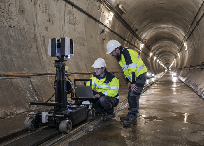 real road tunnel inspection with a tripod-mounted unbranded physical 3D LiDAR scanner and engineers measuring lining convergence validation scene 3
