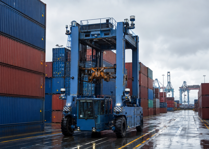 container-terminal straddle carrier equipped with physical 3D LiDAR moving between stacked containers in a realistic LiDAR application scene