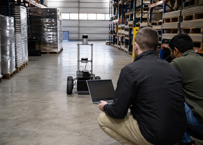engineering team comparing two unbranded physical 3D LiDAR sensors on an interoperability test bench with timing equipment validation scene 3