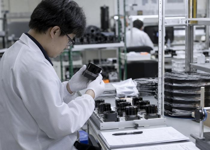 real LiDAR production quality laboratory with unbranded physical sensors, serialized component trays, inspection microscope and traceability workstation with unreadable screens validation scene 3