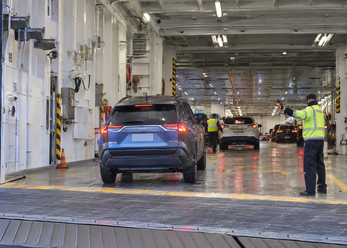 real vehicle ferry car deck with cars, ramp and an unbranded physical LiDAR parking sensor during supervised loading in a realistic LiDAR application scene