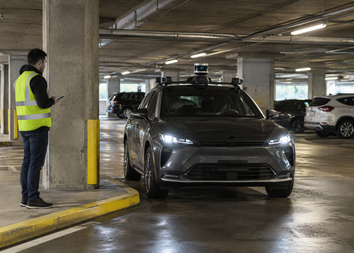 real parking garage with an unbranded passenger vehicle carrying visible physical LiDAR sensors during automated valet parking validation in a realistic LiDAR application scene