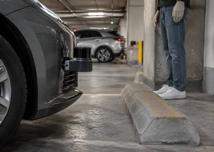 real parking garage with an unbranded passenger vehicle carrying visible physical LiDAR sensors during automated valet parking validation validation scene 2