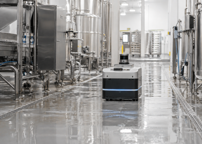 real food-processing washdown room with stainless equipment and an unbranded mobile robot carrying visible physical LiDAR during sanitation validation validation scene 3